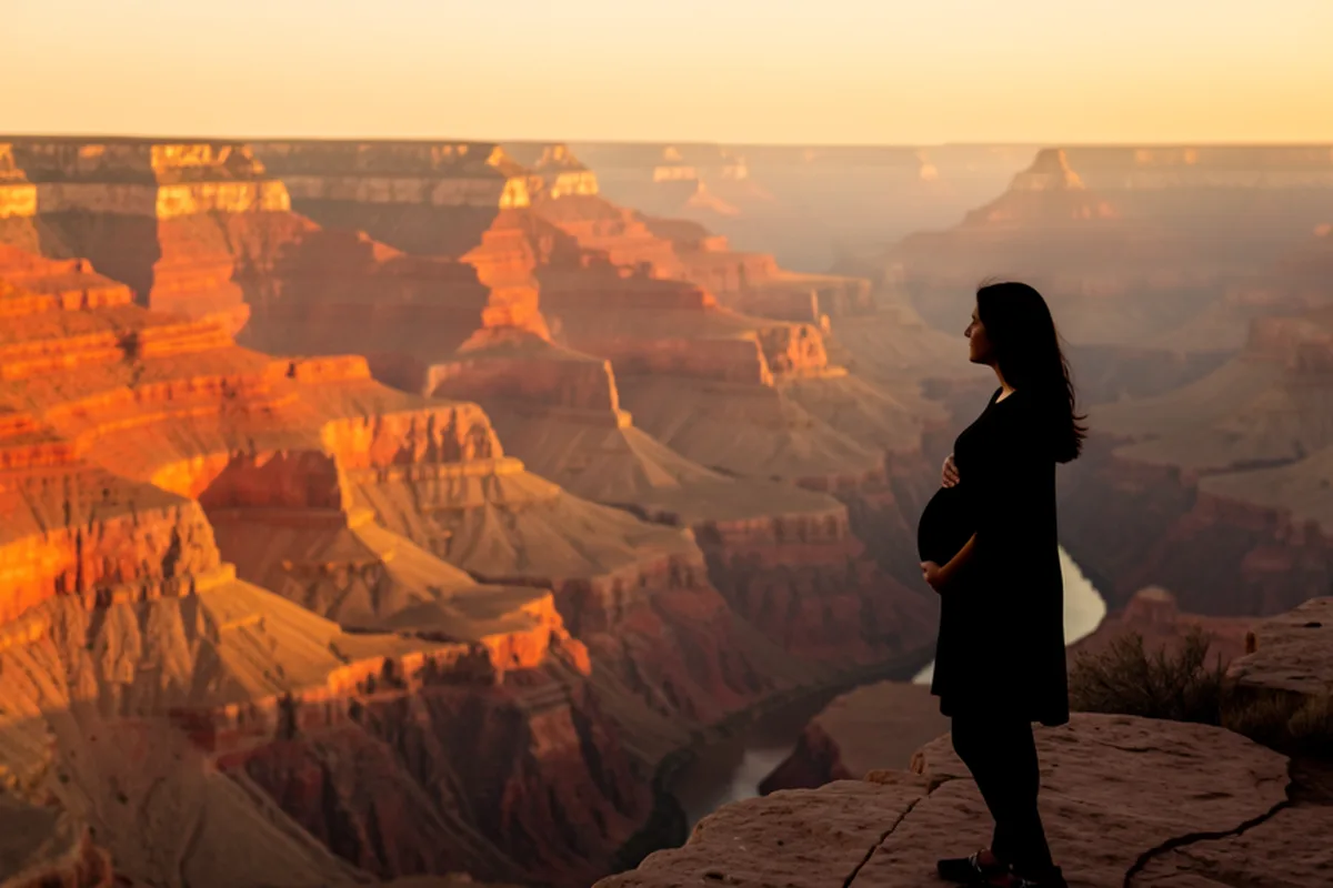 Grand Canyon at golden hour, a pregnant woman silhouetted on the canyon rim looking across the vast layered rock formations