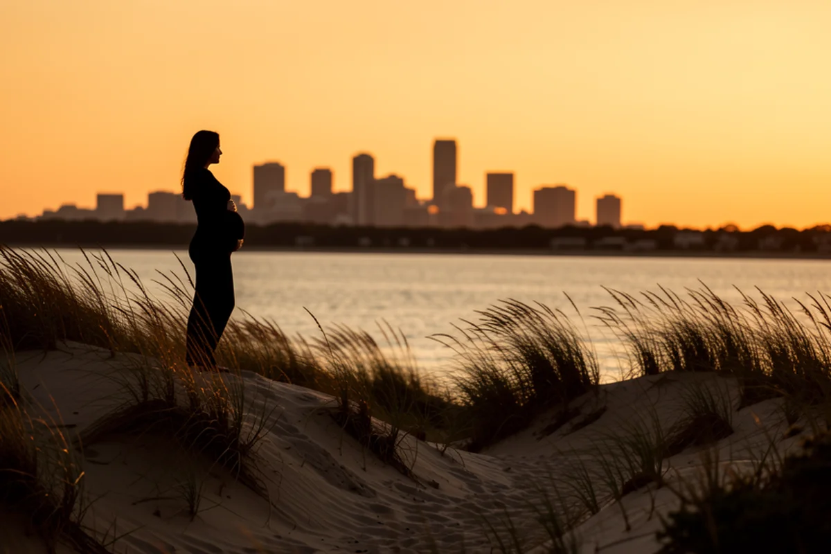 Indiana Dunes at golden hour along Lake Michigan, a pregnant woman silhouetted on a dune looking across the water toward the Chicago skyline